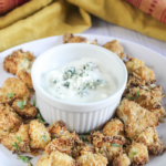 a picture of air fried cauliflower on a plate with dip