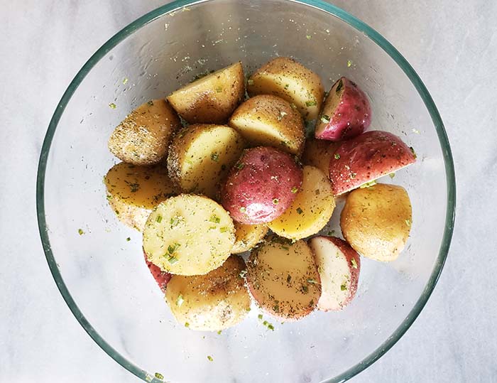 uncooked baby potatoes in a bowl with the seasoning mix