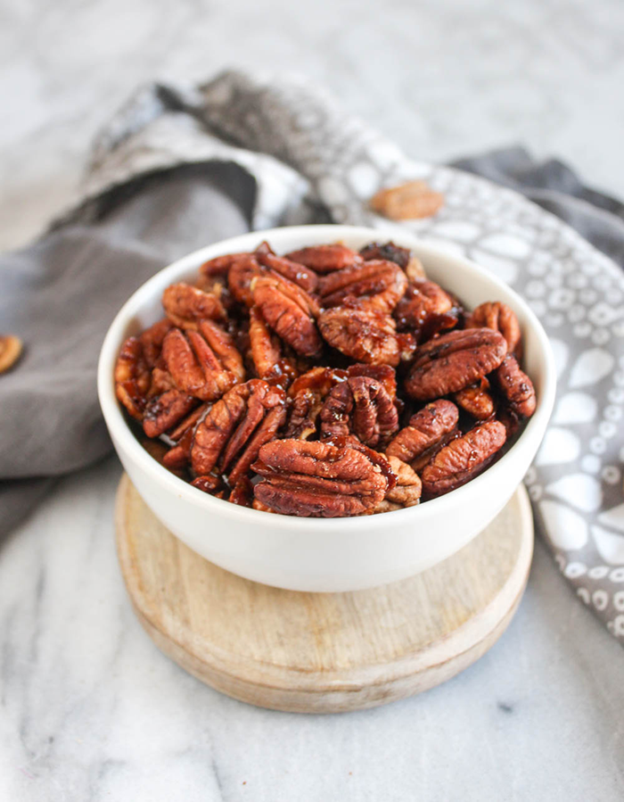 A white bowl filled with sweet and spicy pecans.