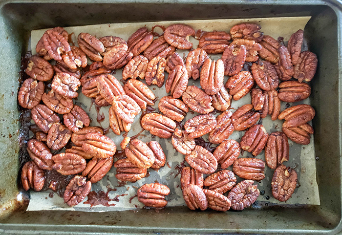 an overhead view of pecans roasted in a pan
