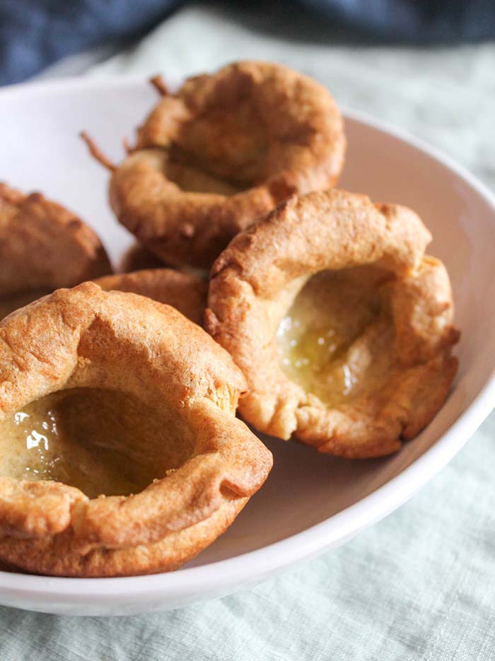 a close up shot of yorkshire puddings in a white dish