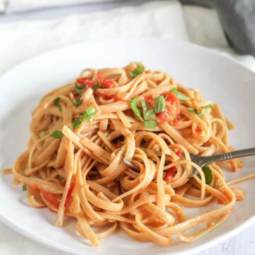 A white plate of pasta with blush sauce