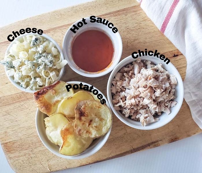the ingredients for buffalo potato nachos: potatoes, chicken, hot sauce, cheese