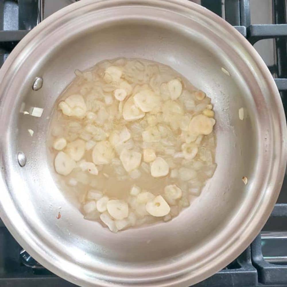 Step one: a photograph of garlic, onions cooking in a skillet