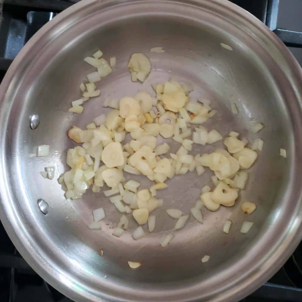 Blush sauce process step 1, garlic and onions cooking in a pan