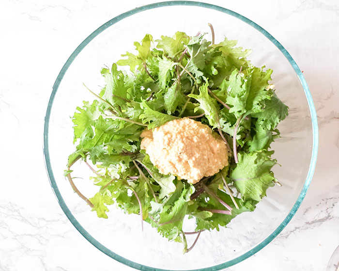 cashew puree or cheese in a bowl with kale leaves