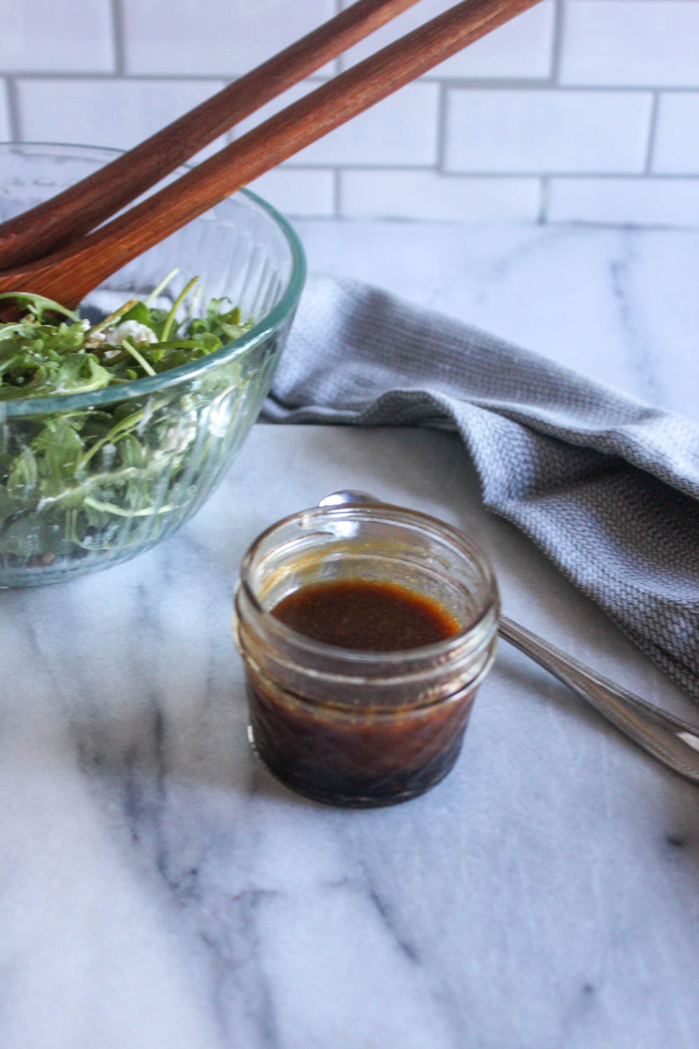 salad dressing mixed in a jar with a bowl of salad