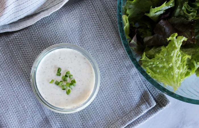 ranch dressing in a jar with chopped onions on top