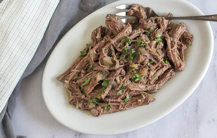 an overhead view of the shredded beef on a plate with a fork