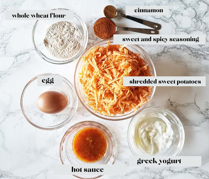 a picture of the ingredients for sweet potato fritters: hot sauce, yogurt, shredded sweet potatoes, egg, flour, spicy seasoning, cinnamon