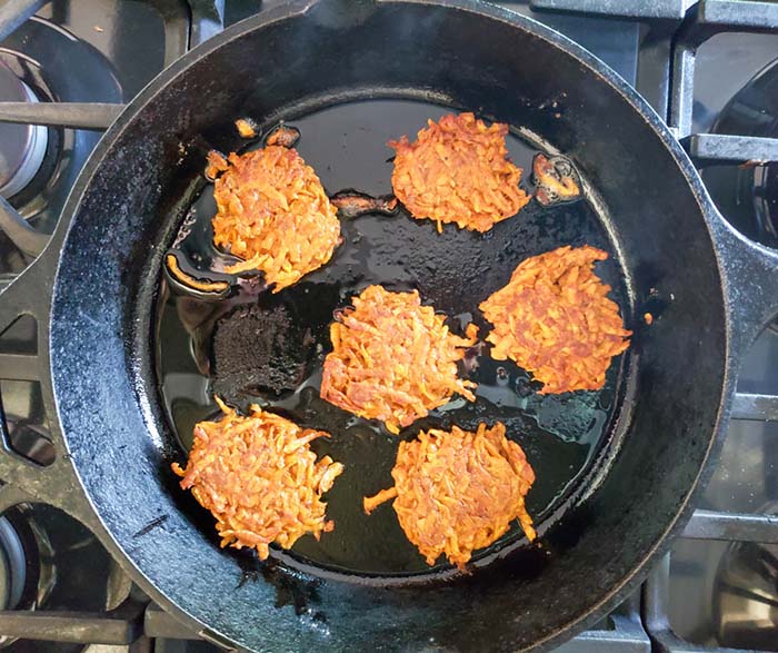 sweet potato fritters in a pan cooking