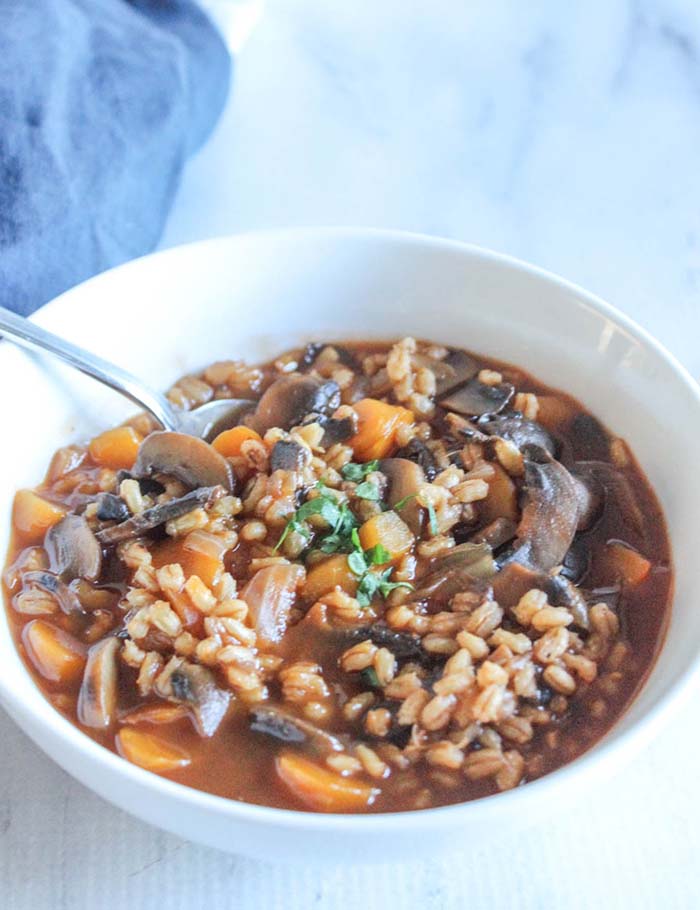 mushroom barley soup in a bowl with a spoon