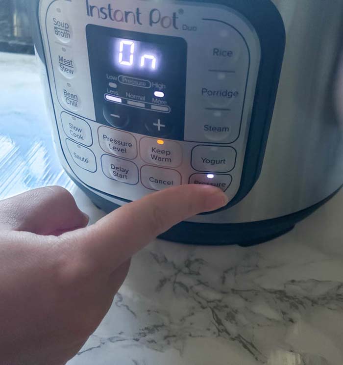 Finger pressing button on instant pot