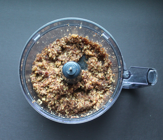 dates and walnuts blended together in a food processor bowl.