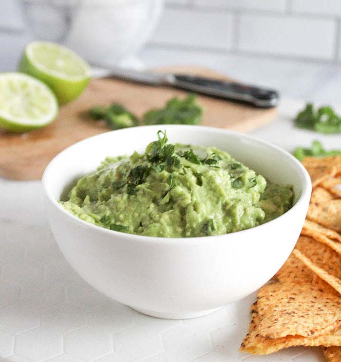 a close up picture of guacamole in a white bowl