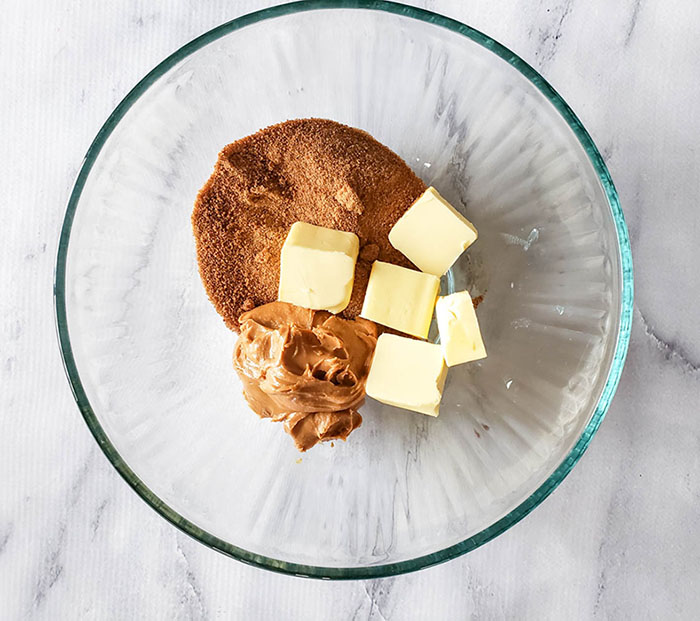 Mixing bowl showing step one of recipe combining sugar, butter and peanut butter.