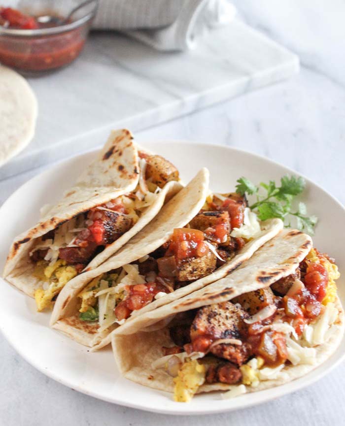 three breakfast tacos on a plate