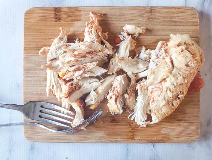 shredded chicken  on cutting board with forks