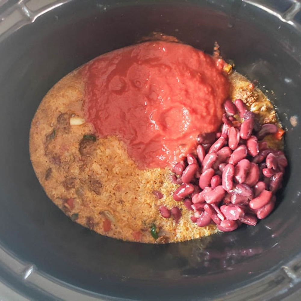 beer chili in a crockpot step 4 teh ingredients in a slow cooker ready to slow cook