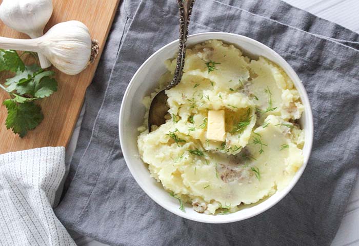 mashed potatoes in a bowl with butter and dill