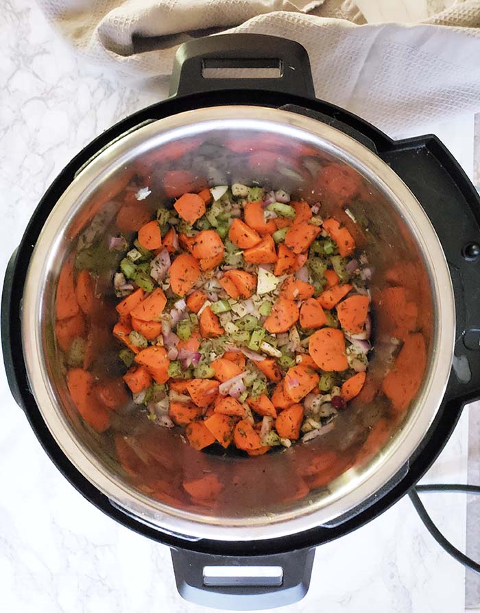 carrots, onions, celery and herbs cooking in instant pot