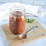 enchilada sauce in a jar with a spoon in front