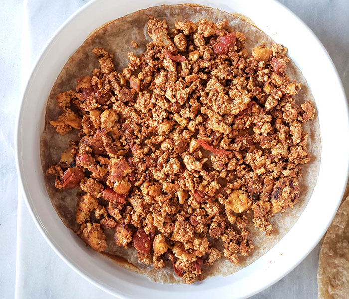 enchilada filling on top of a tortilla in casserole dish