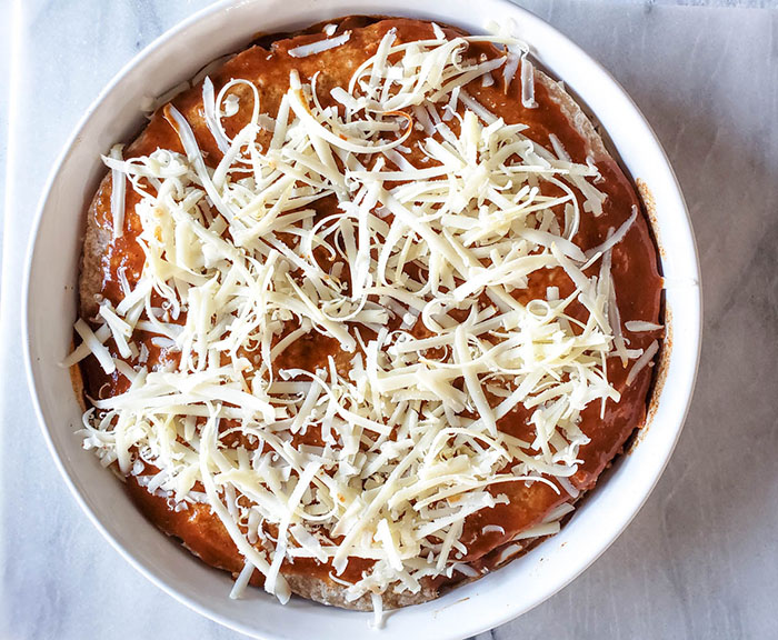 enchilada casserole assembled in a white dish