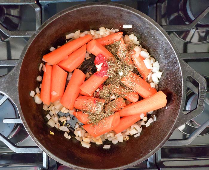 carrots cooking in a dutch oven with onions and garlic