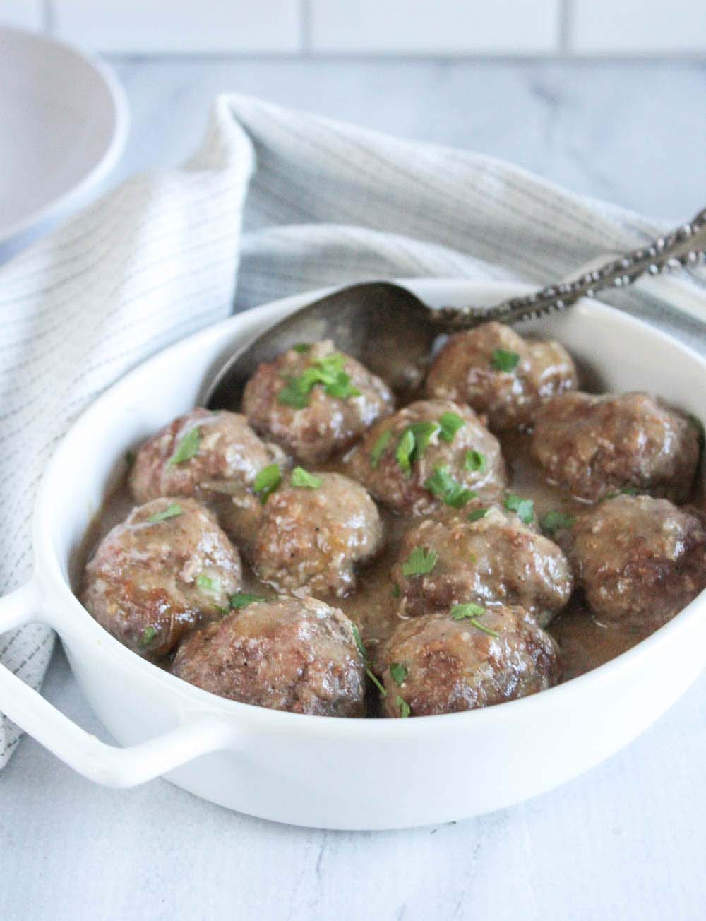 A white casserole dish filled with swedish meatballs