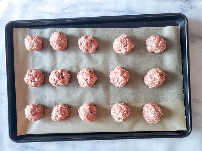 uncooked meatballs on a pan