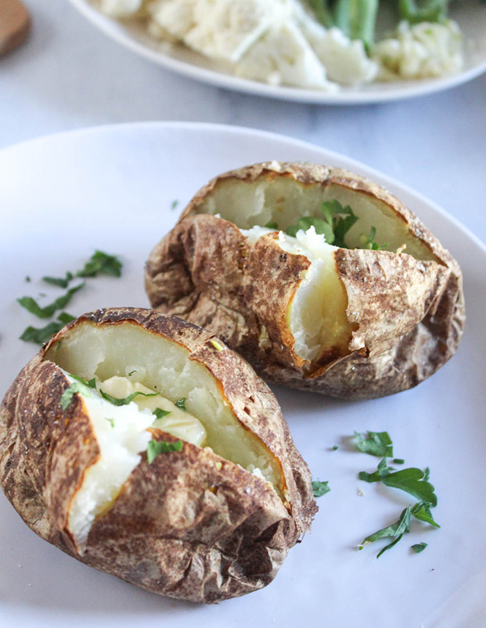 Air Fryer baked potatoes on a plate with parsley