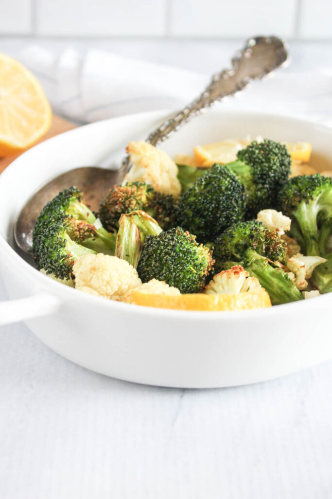 broccoli and cauliflower in a dish with a spoon