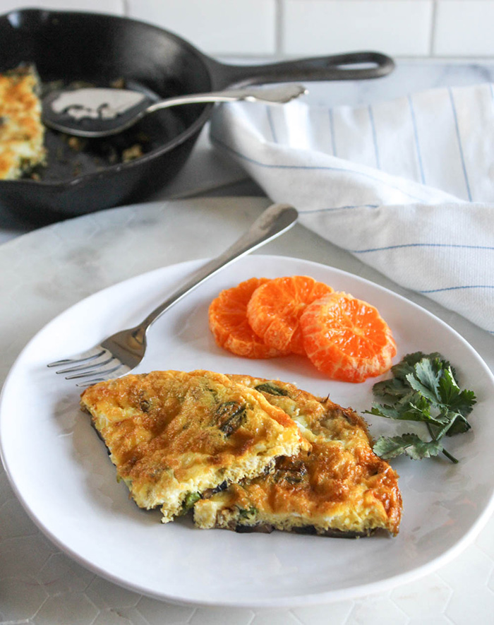 two slices of a frittata with oranges on a plate