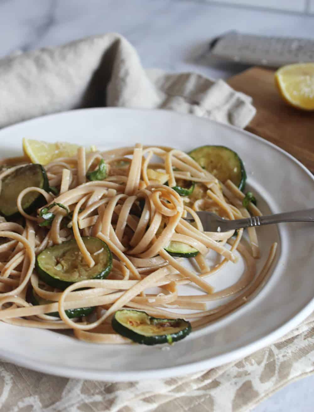 A picture of zucchini pasta on plate with a fork