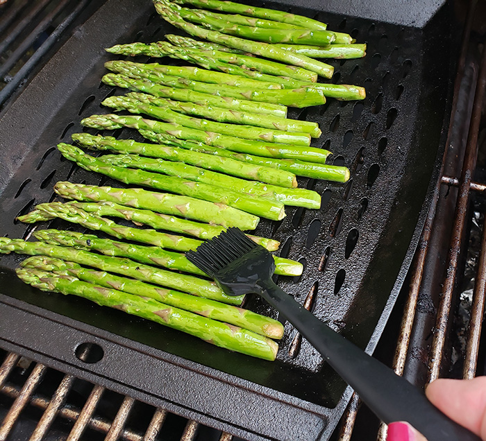 asparagus cooking on a grill basting