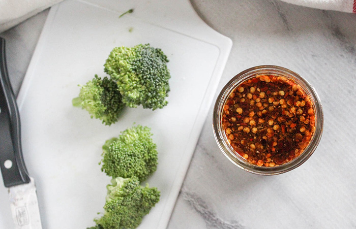 an overhead view of spicy stir fry sauce in a jar with broccoli