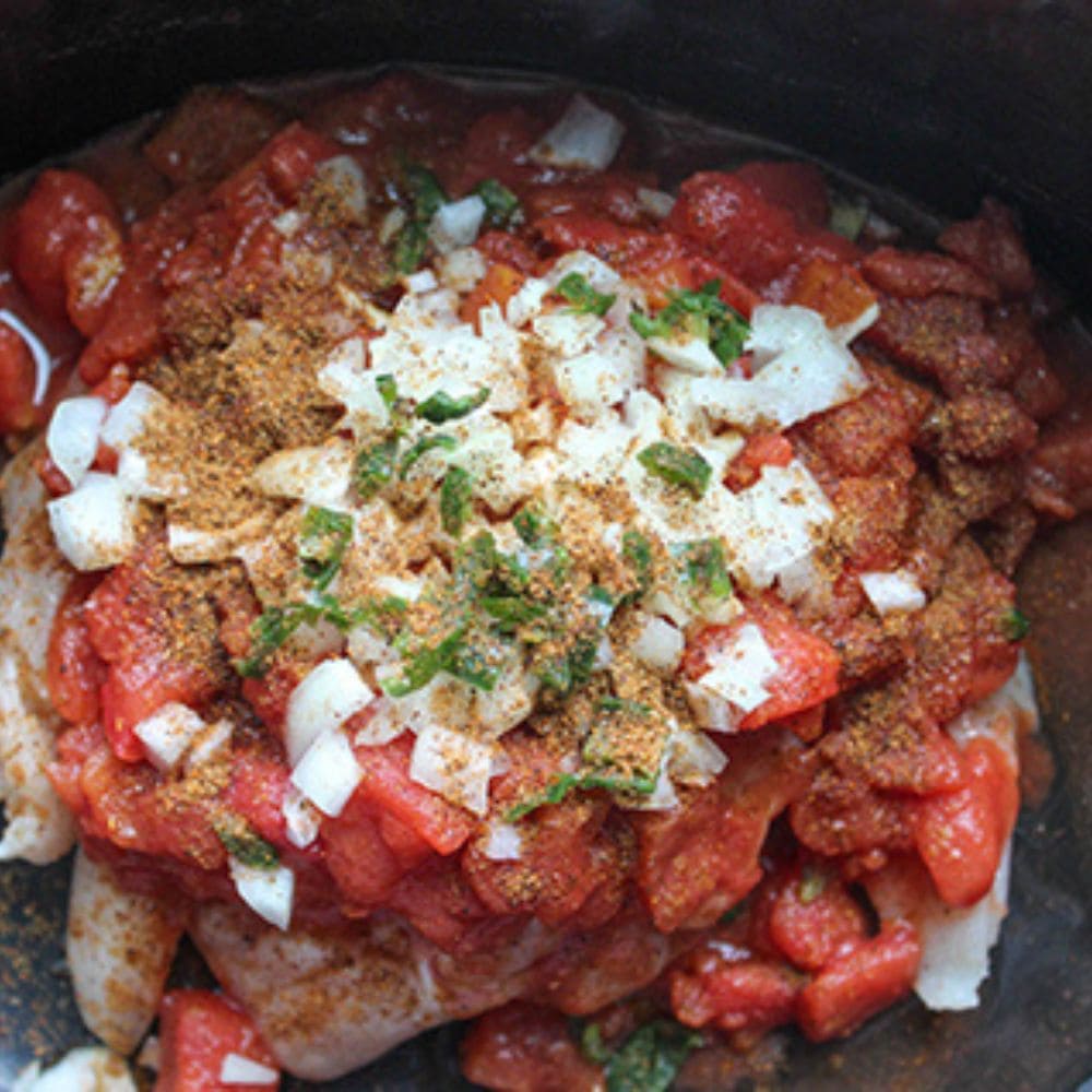 Taco chicken step 2, all of the ingredients in a slow cooker ready to cook