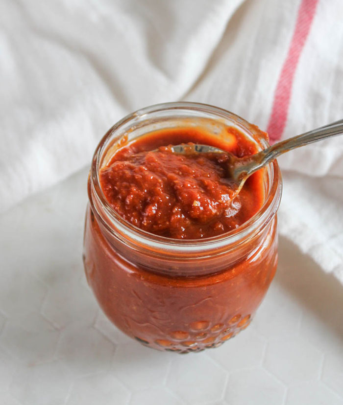 beer bbq sauce in a jar with a spoon on top