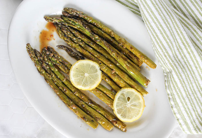 overhead view of asparagus on a plate with lemon