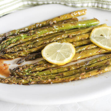 asparagus on a white plate with lemon slices