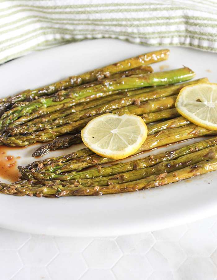 asparagus on a white plate with lemon slices