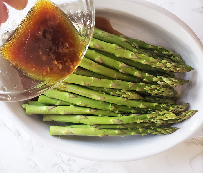 marinade pouring over the asparagus