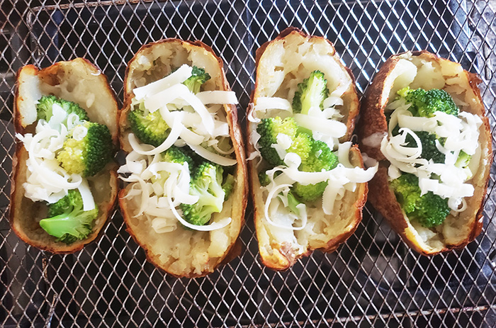 four potato skins with broccoli and shredded cheese