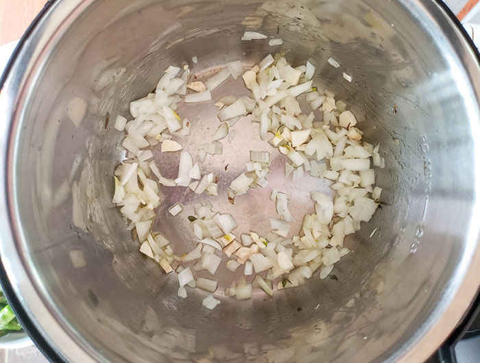 process step two for asparagus risotto. Onions cooking in an instant pot.