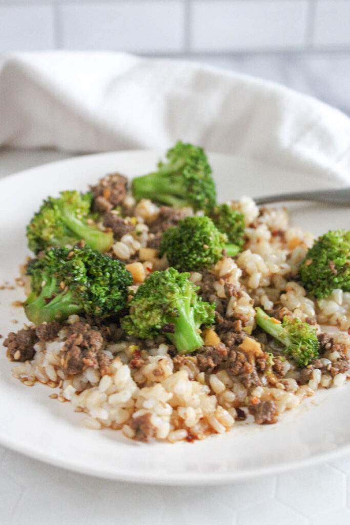 a picture of ground beef with broccoli on a white plate