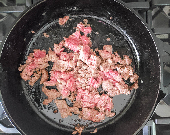 ground beef and broccoli beef cooking in a pan