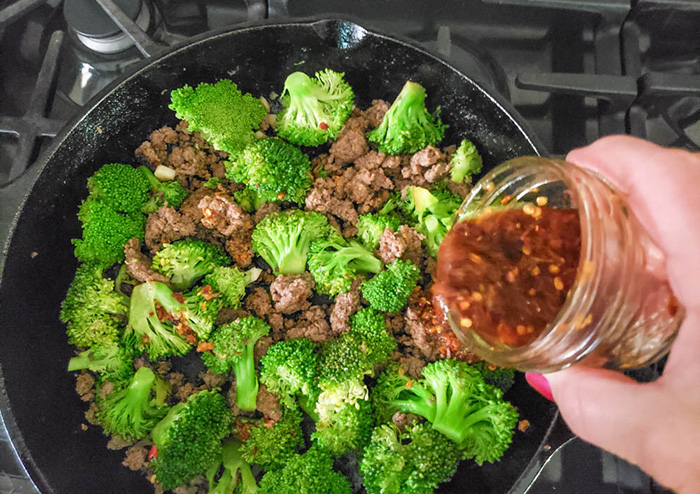 ground beef an broccoli in skillet adding the sauce