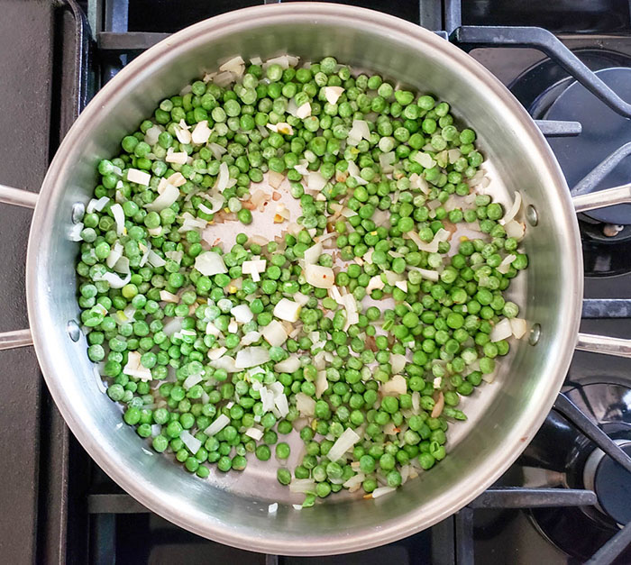 Process Onions and peas cooking in a skillet