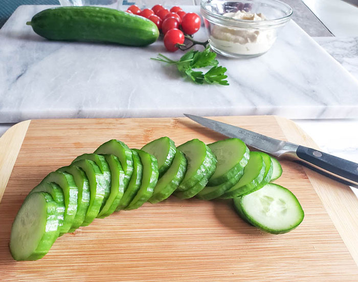 a sliced cucumber on a cutting board with a knife